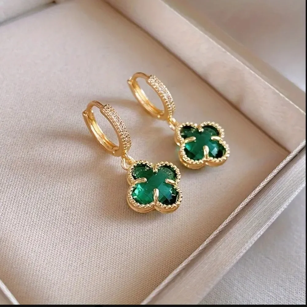 clover-shaped dangle earrings featuring green stones and gold plating with paved